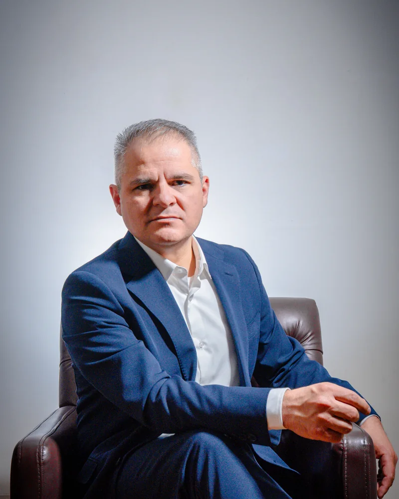 Dr. Marco Carmona sentado con traje azul, en una fotografía de su sesión de 2026