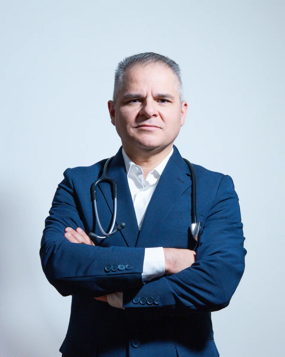Retrato profesional del Dr. Marco Antonio Carmona Escamilla con traje y estetoscopio